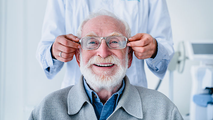 older man trying on glasses